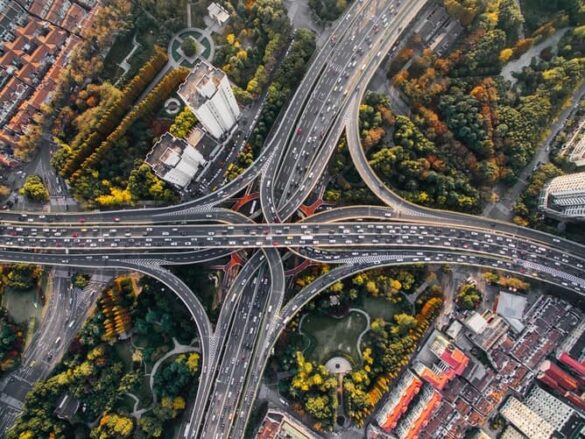 Urbanização e meio ambiente concentrado em uma imagem do alto de uma cidade com pontes para a circulação de carros com vegetal urbana em volta