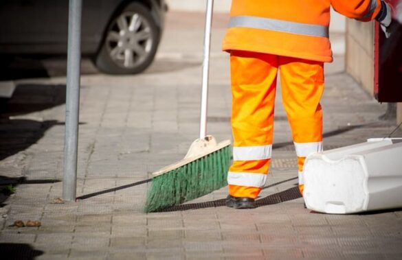 profissional-de-limpeza-com-uniforme-laranja-utilizando-vassoura-para-gestao-dos-servico-de-limpeza-urbana